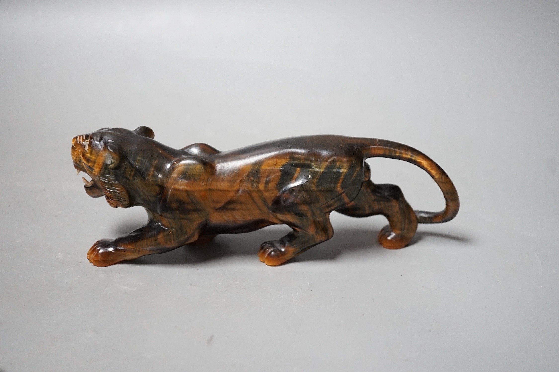 A carved tigers eye model of a tiger with paste set eyes. Makers mark ‘WG’ to paw underside. Numbered 974. 19cm long